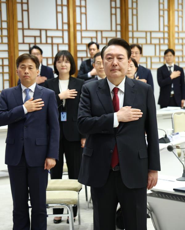 President Yoon Suk Yeol (right, front row) salutes to the natio<em></em>nal flag as he presided over a meeting with semico<em></em>nductor industry leaders at his office in Seoul on April 9. (Pool photo via Yonhap)